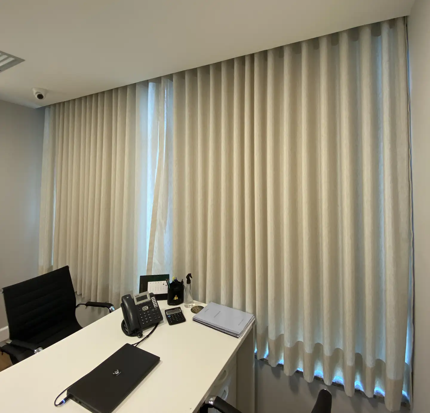 Sala de trabalho com cortinas de tecido em tom areia