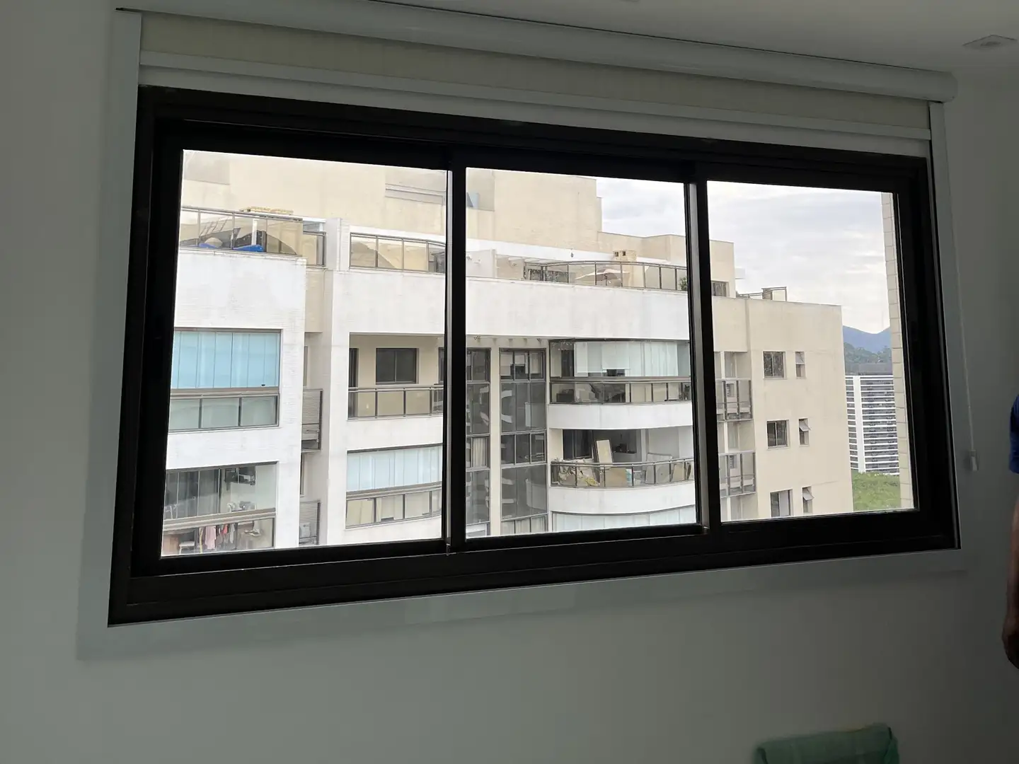 Janela de quarto com persiana rolô blackout recolhida