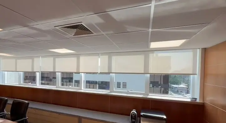 Telas solares motorizadas a meia altura em uma faixa de janelas de sala de reunião