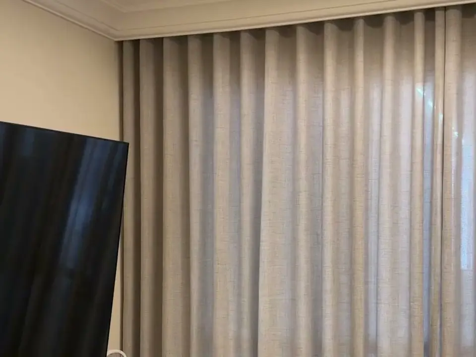 Cortina de voil em linho misto vista de perto, ao lado da TV